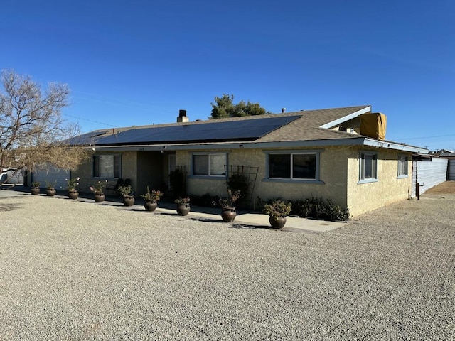 single story home with solar panels and a garage