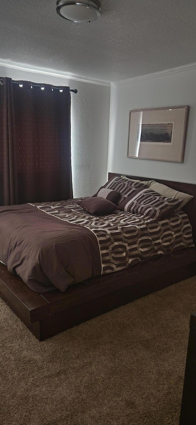 carpeted bedroom featuring a textured ceiling and ornamental molding