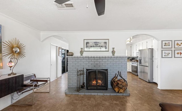 living room with ornamental molding, a fireplace, and dark tile patterned flooring