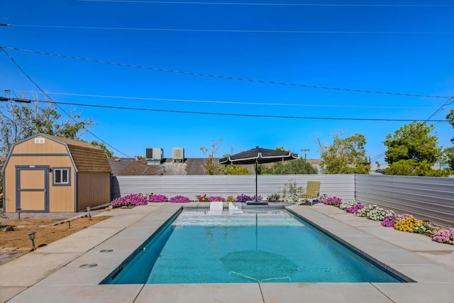 view of swimming pool with central air condition unit and a shed