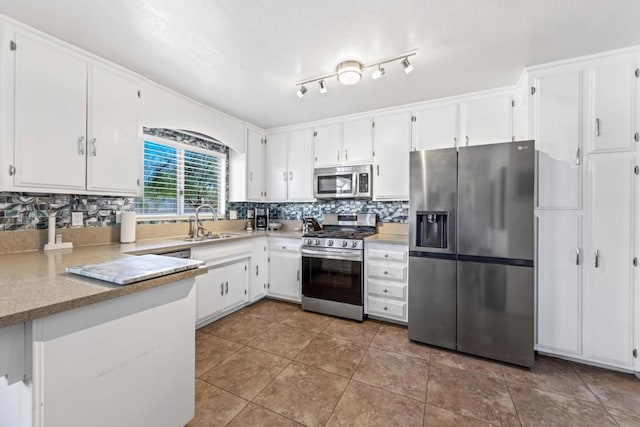 kitchen featuring white cabinets, tile patterned floors, stainless steel appliances, sink, and backsplash