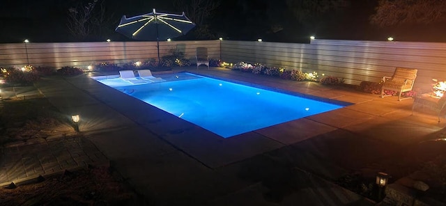 view of pool at twilight