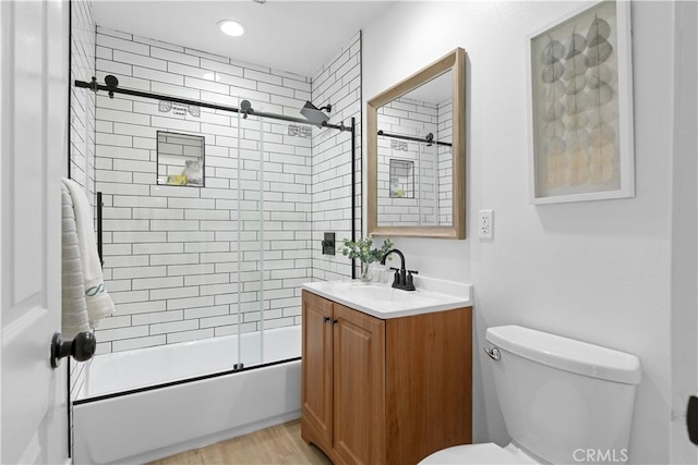 full bathroom featuring toilet, vanity, bath / shower combo with glass door, and hardwood / wood-style flooring