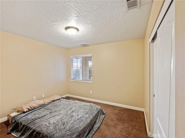 bedroom featuring a closet, a textured ceiling, and carpet flooring