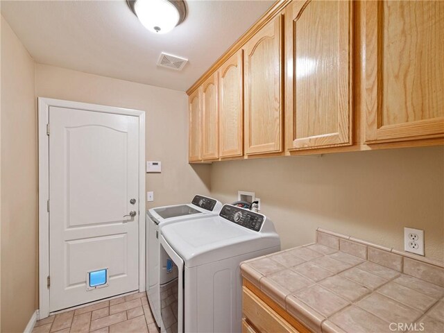 washroom with cabinets and separate washer and dryer