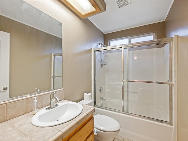 full bathroom featuring toilet, bath / shower combo with glass door, and vanity