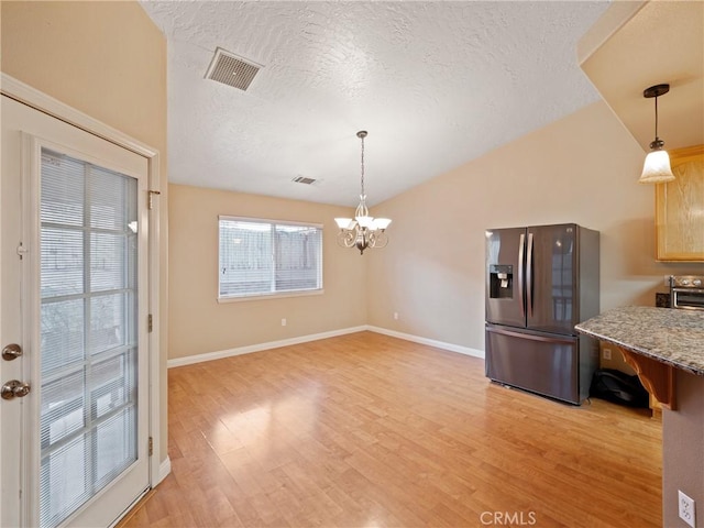 kitchen featuring stainless steel fridge with ice dispenser, a chandelier, pendant lighting, and light wood-type flooring