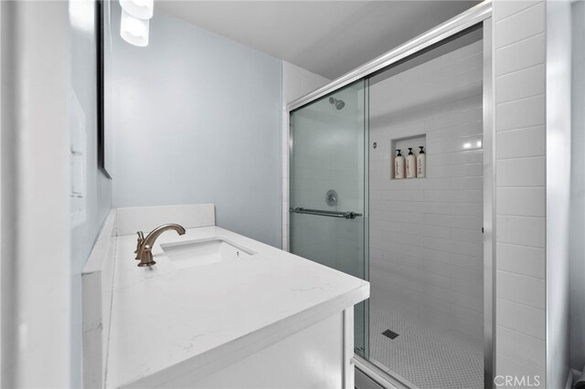 bathroom featuring vanity and a shower with shower door