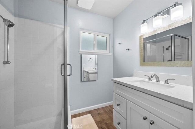 bathroom featuring vanity, an enclosed shower, and wood-type flooring