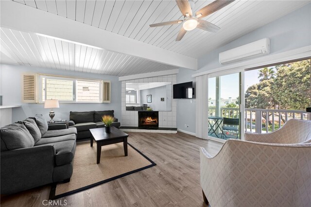 living room with ceiling fan, lofted ceiling with beams, a wall unit AC, wood-type flooring, and wood ceiling