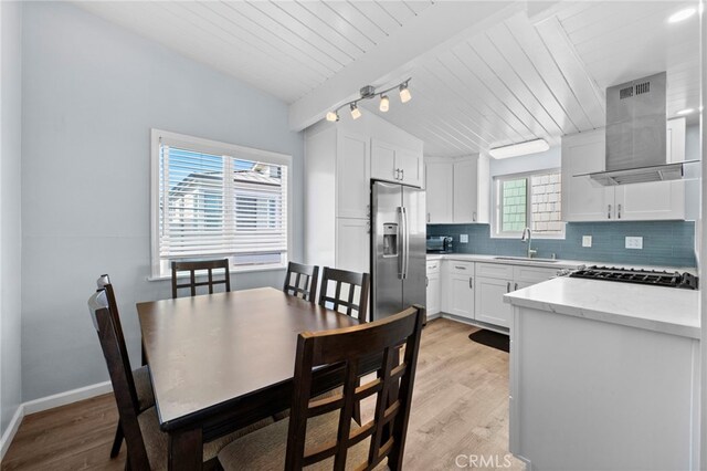 kitchen with a healthy amount of sunlight, sink, white cabinetry, and stainless steel refrigerator with ice dispenser
