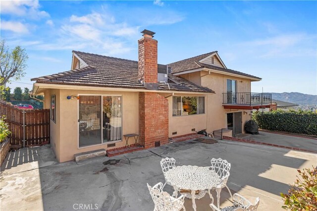 back of house featuring a patio area, a mountain view, and a balcony