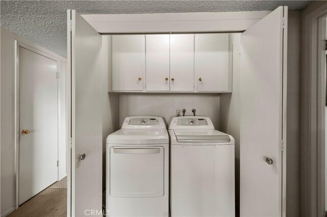 laundry room with carpet floors, washer and dryer, and cabinets