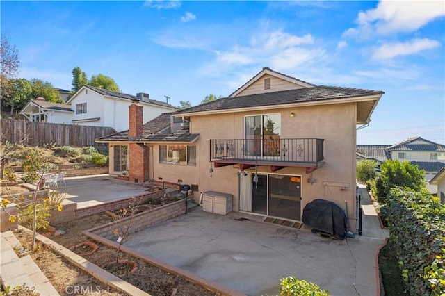 back of property featuring a balcony and a patio