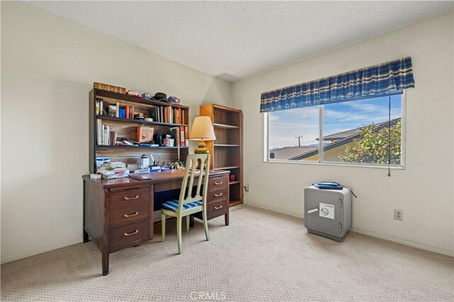 office space with a textured ceiling and light carpet