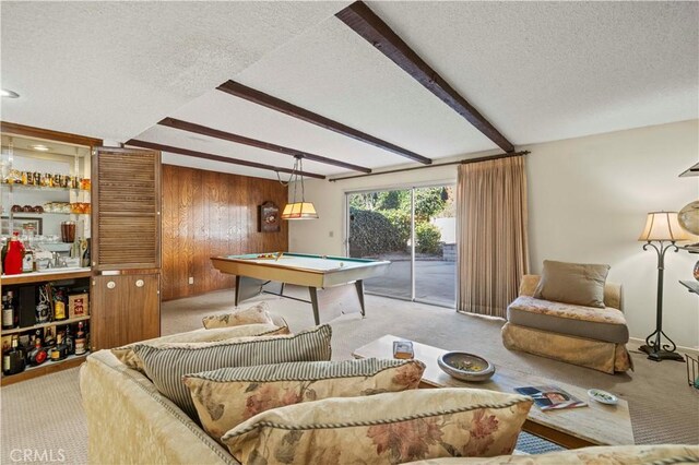 game room featuring a textured ceiling, pool table, beamed ceiling, and wooden walls