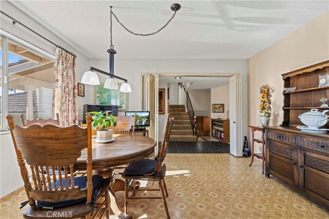 dining area featuring a wealth of natural light and a textured ceiling