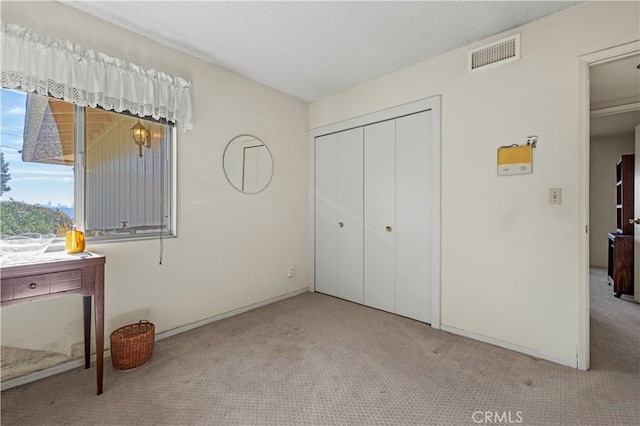 unfurnished bedroom with light carpet and a closet