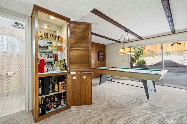 rec room featuring light carpet, wood walls, billiards, a textured ceiling, and beamed ceiling