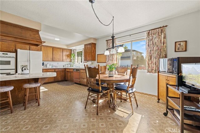 dining area featuring a wealth of natural light and a textured ceiling