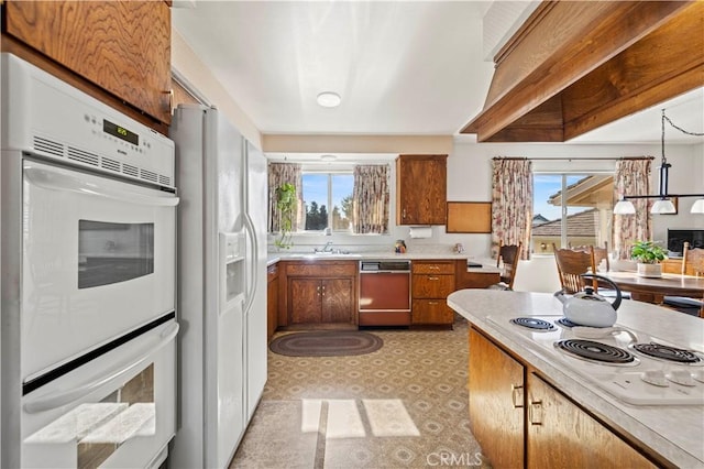 kitchen featuring sink, white appliances, and a chandelier