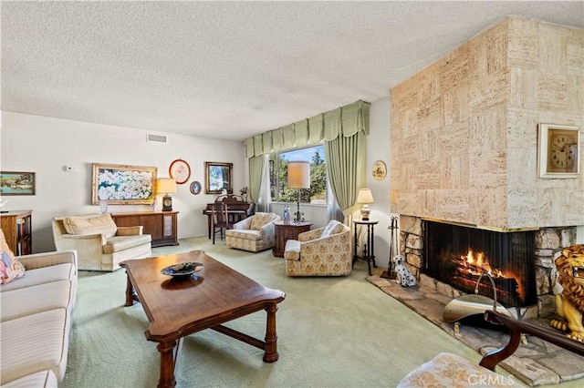 carpeted living room featuring a fireplace and a textured ceiling