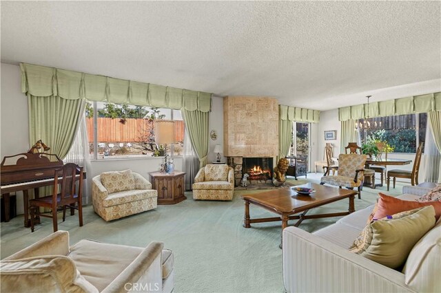 carpeted living room featuring a textured ceiling, a chandelier, and a multi sided fireplace