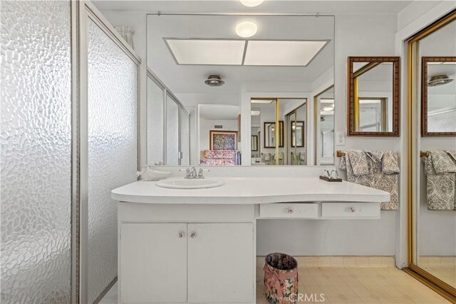 bathroom with vanity and a shower with door