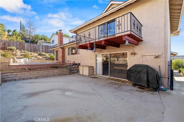 rear view of property with a balcony and a patio