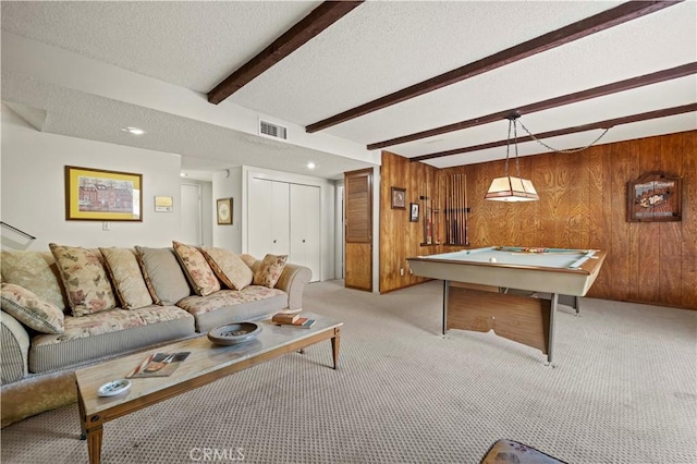 living room featuring wooden walls, light colored carpet, billiards, a textured ceiling, and beamed ceiling