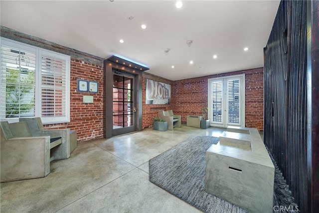 living room featuring french doors and brick wall