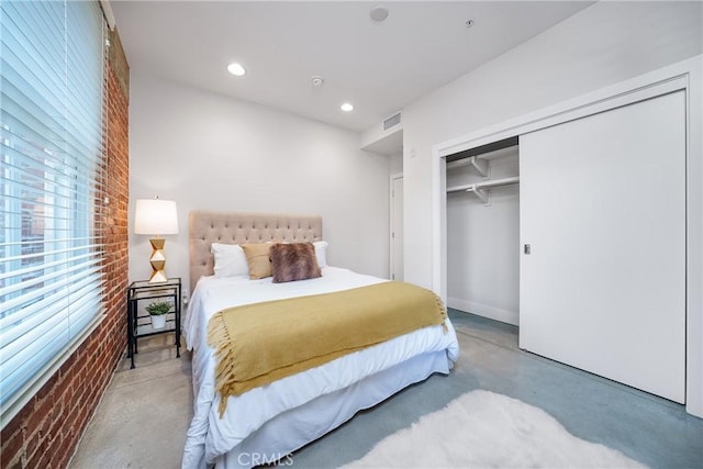 bedroom featuring a closet and brick wall