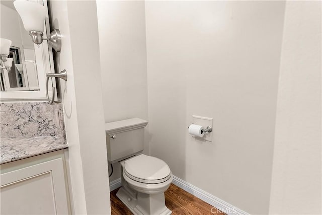 bathroom featuring vanity, hardwood / wood-style floors, tasteful backsplash, and toilet