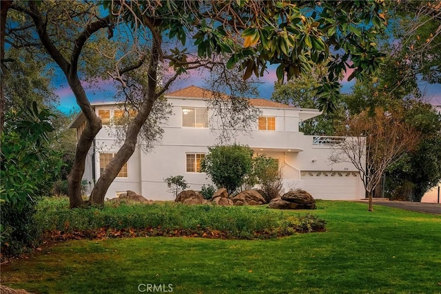 view of front of property with a garage and a lawn