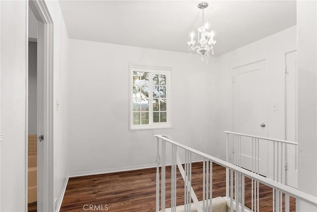 hallway featuring dark wood-type flooring and a chandelier