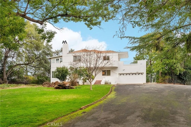 view of front of home with a balcony, a garage, and a front yard