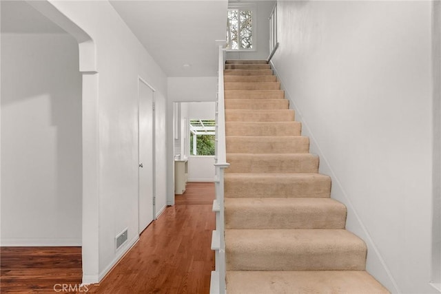 stairs featuring hardwood / wood-style floors