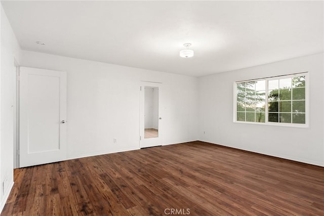 spare room with dark hardwood / wood-style floors