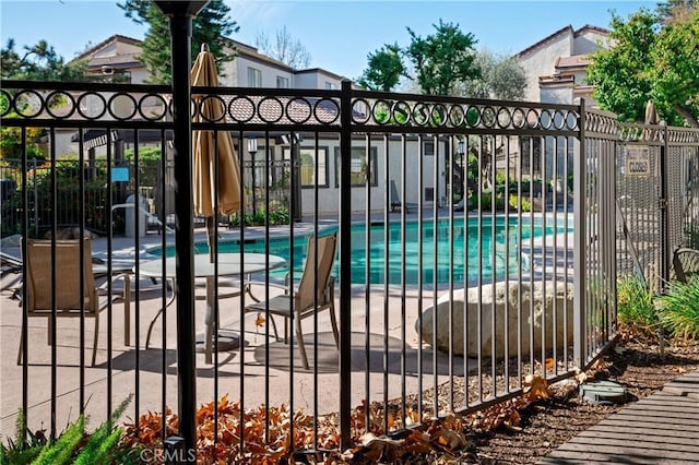 view of gate featuring a patio area and a community pool