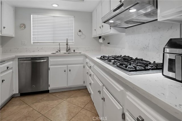 kitchen featuring under cabinet range hood, stainless steel appliances, white cabinetry, and a sink