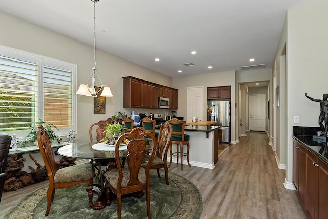 dining room featuring hardwood / wood-style flooring and a notable chandelier