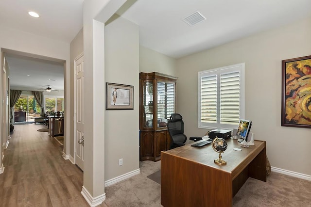 carpeted office with ceiling fan