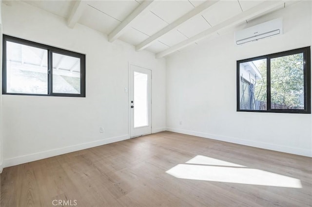 empty room featuring vaulted ceiling with beams, light hardwood / wood-style flooring, and a wall unit AC