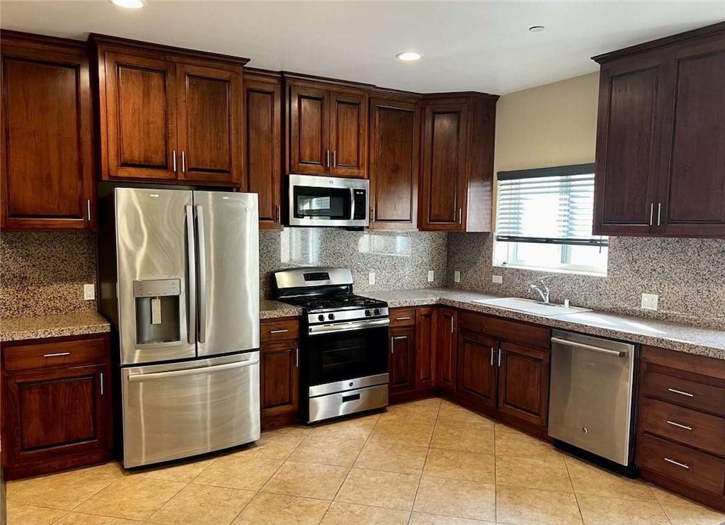 kitchen with sink, stainless steel appliances, and tasteful backsplash