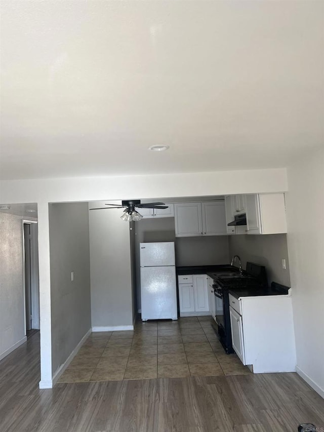 kitchen featuring black stove, white cabinetry, white fridge, dark hardwood / wood-style floors, and ceiling fan