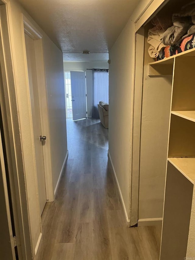 hallway with dark hardwood / wood-style flooring and a textured ceiling