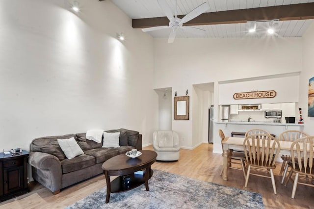 living room featuring beam ceiling, wooden ceiling, light hardwood / wood-style floors, and ceiling fan