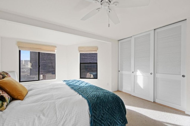 carpeted bedroom with ceiling fan and a closet