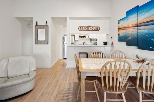 dining space featuring sink and light hardwood / wood-style floors