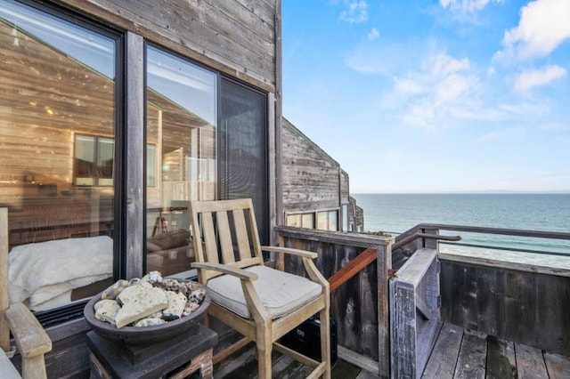 balcony with a water view and a view of the beach